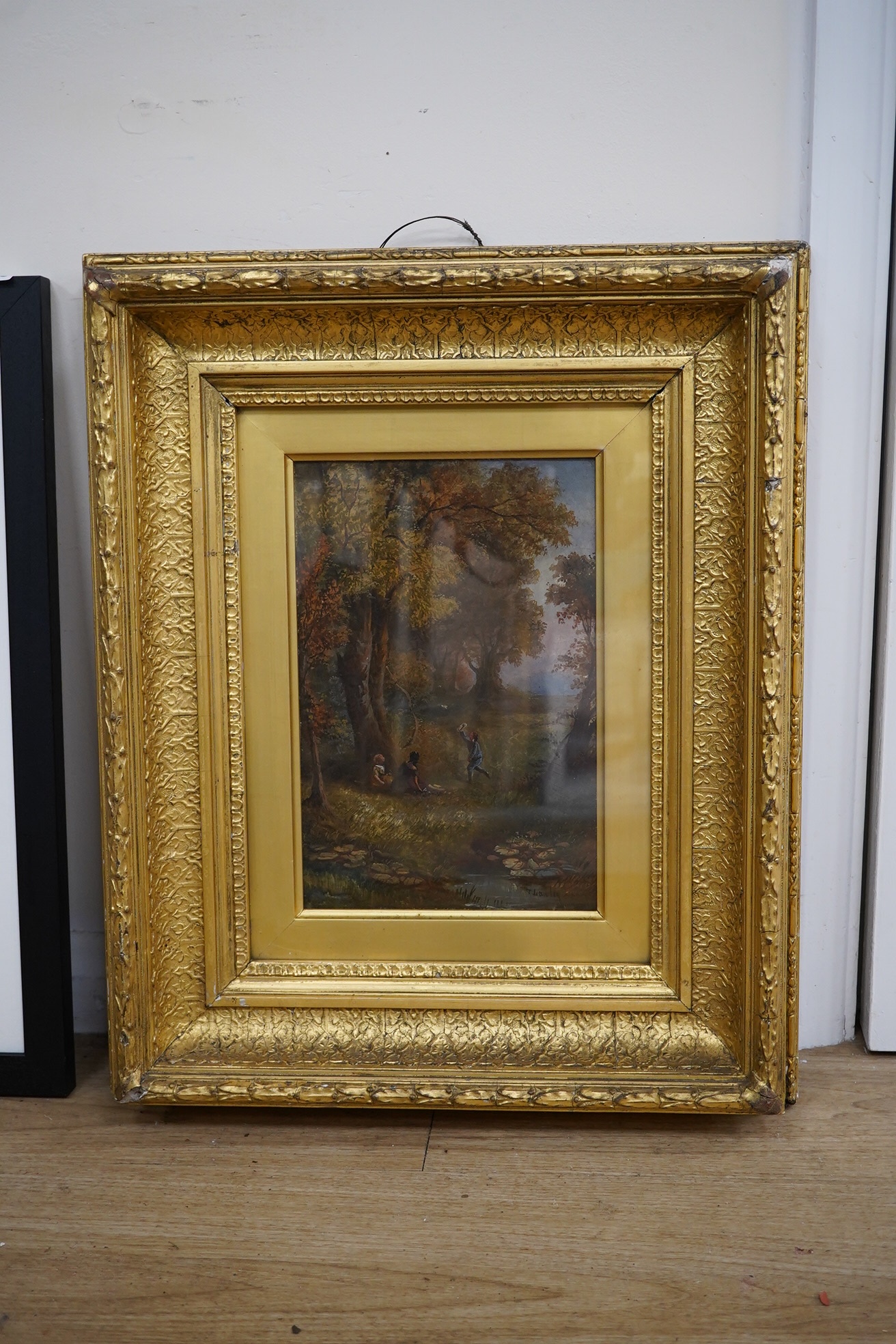 T Lawley (19th. C), oil on canvas, Woodland landscape with three figures beside a stream, signed, 29 x 19cm, ornate gilt framed. Condition - good